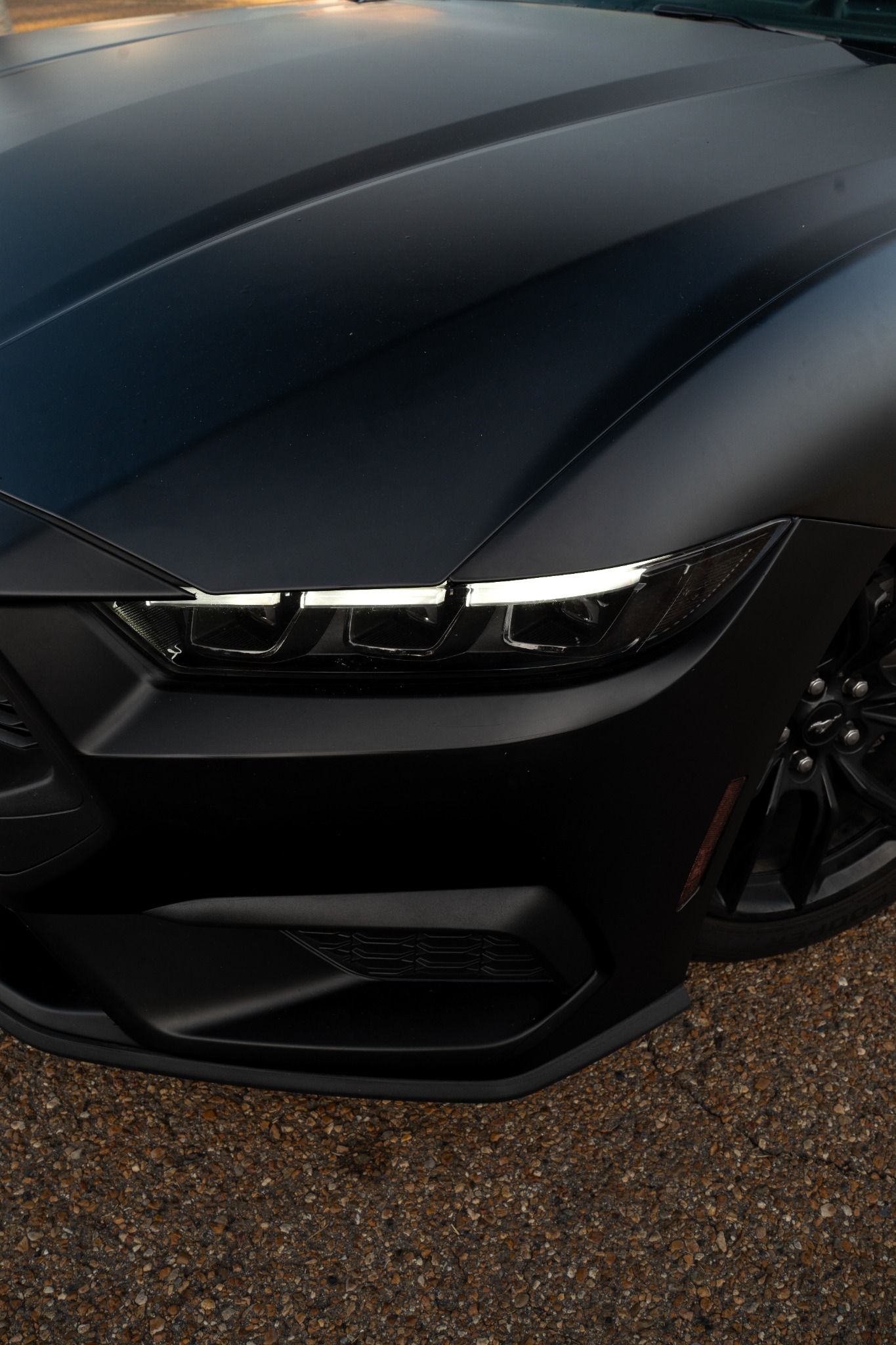 Close detail of satin black Ford Mustang front end
