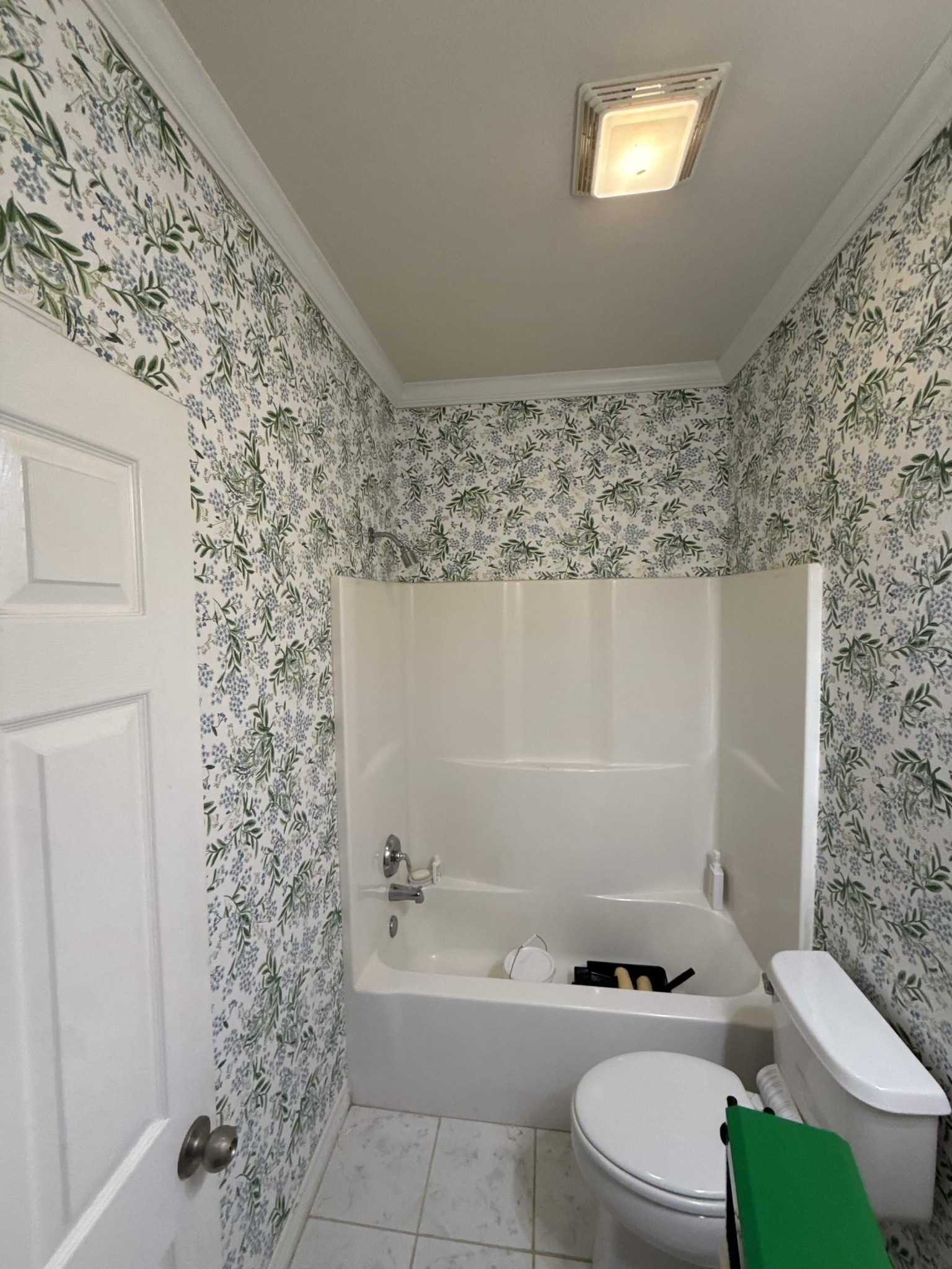 Botanical wallpaper installed around a bathroom tub and walls