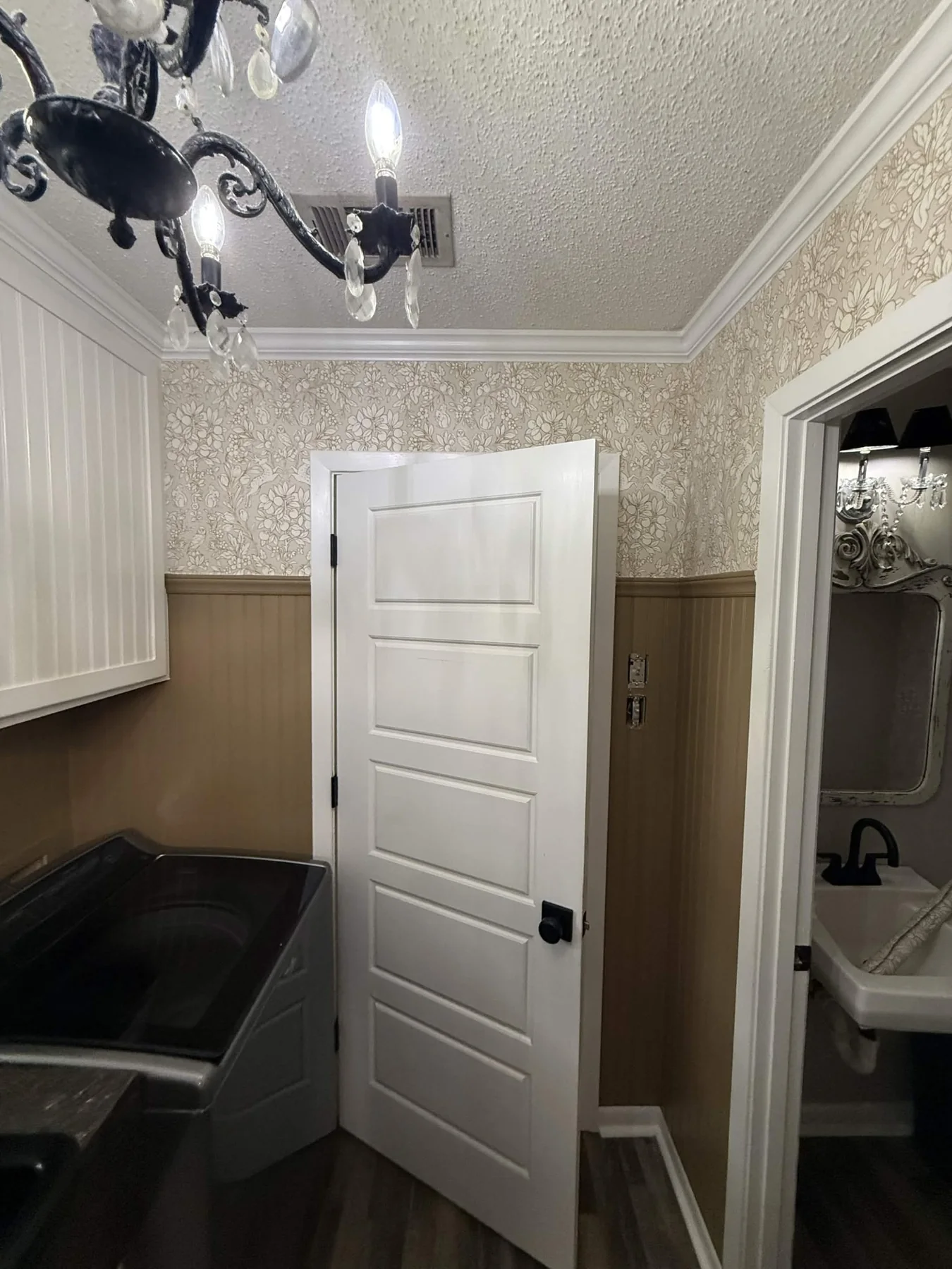 Residential floral wallpaper above wall paneling